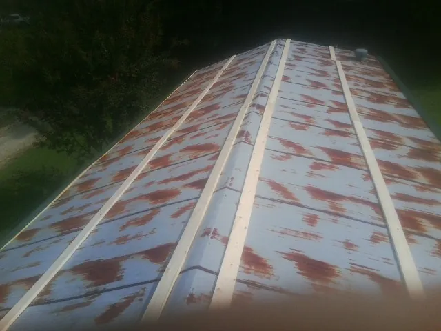 Rusted metal roof panels with new wood purlins before replacement — Storm Damage Roof Repair in Clio by Roofing Brothers